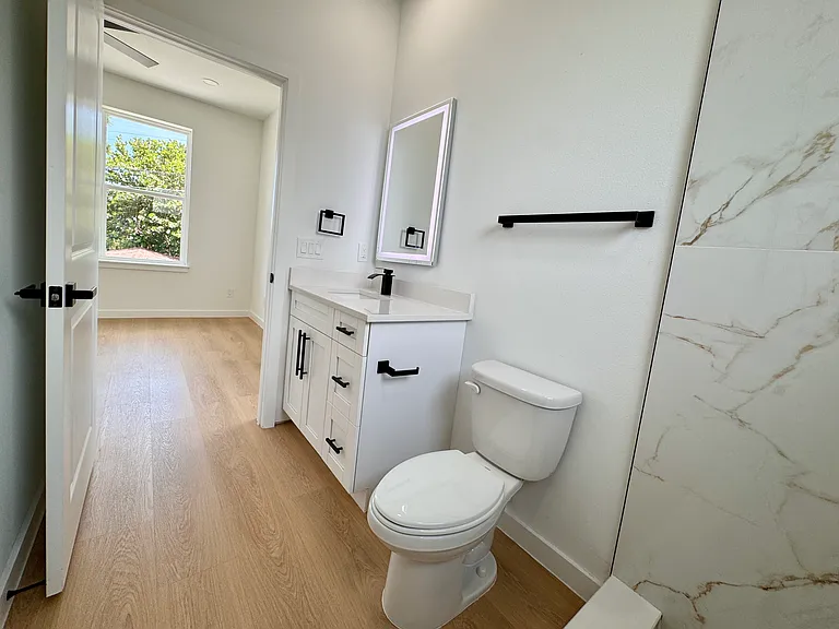 Sleek bathroom with walk-in shower and LED vanity mirror.