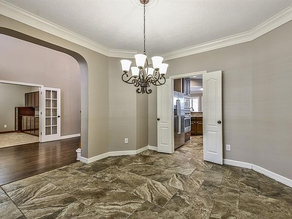 Formal dining room boasts crown molding and access to the kitchen.