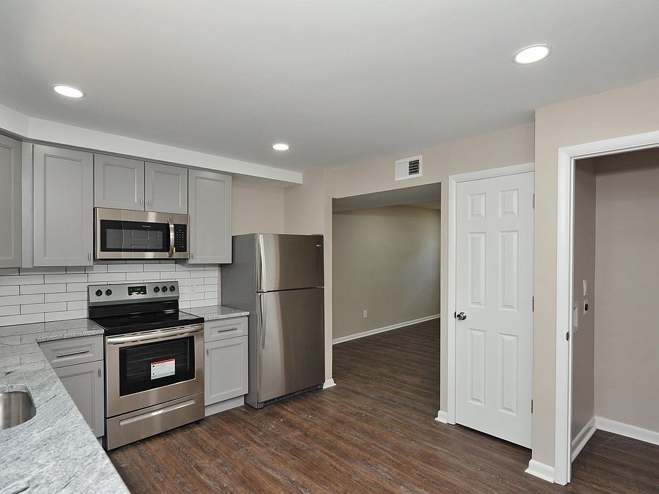 View of the kitchen, the HVAC closet (door closed) and the laundry closet on the right (door open).