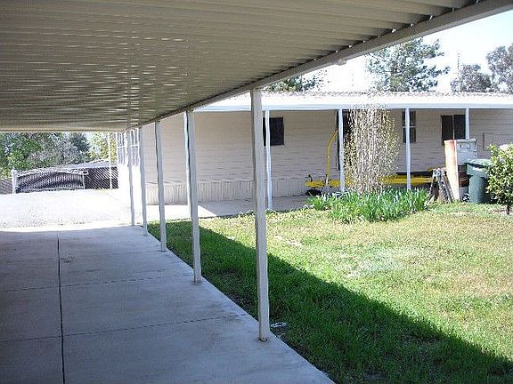 Alumawood carports on home and garage provide covered parking for 4 vehicles