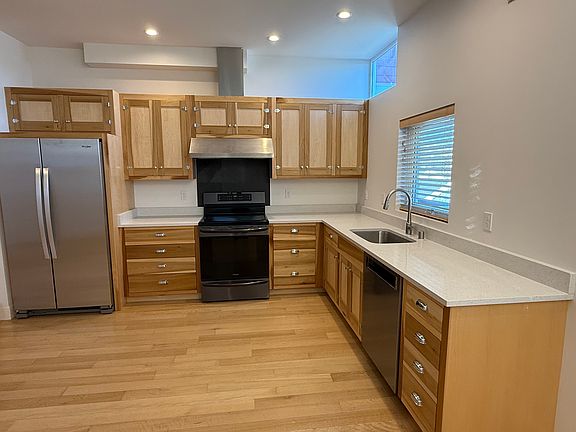 Custom kitchen cabinets with generous storage and sparkling white quartz counters with mirror flecks.