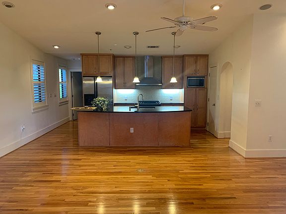 Open concept kitchen/living/dining. Arched entry to separate office/work space is to the right of the kitchen.