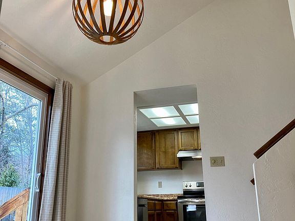 Dining room with new light fixture sourced from local, independent shop. View to the kitchen and patio.