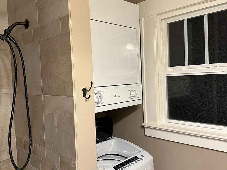 Main floor bathroom with tub shower and washer/dryer