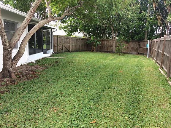Fenced private fenced backyard with a screened porch