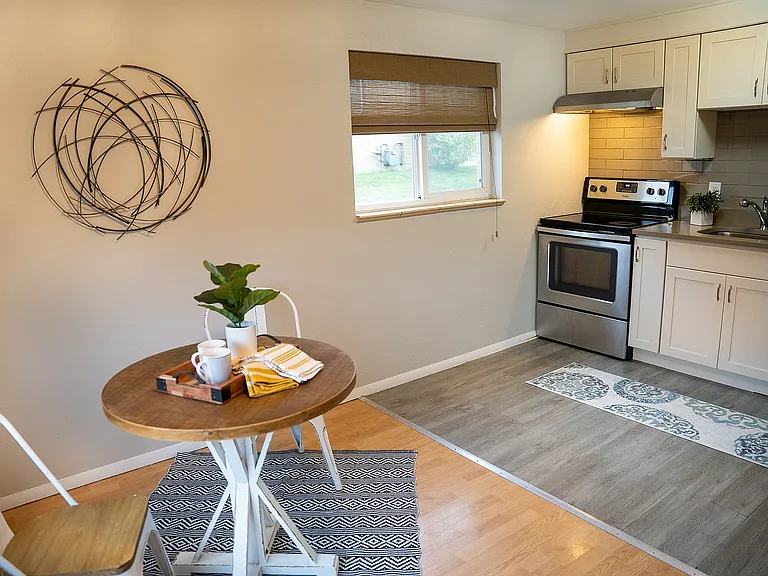 Inviting kitchen with modern appliances, a cozy dining area, and stylish wall art for a warm ambiance.