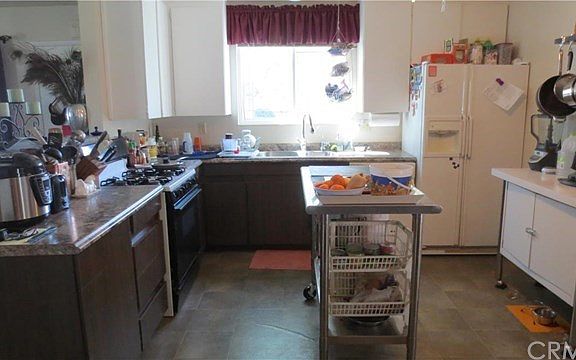 Kitchen - gas stove, formica countertops pot rack and more