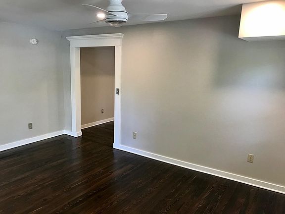 Large living room with tons of natural light and gorgeous hardwood floors throughout