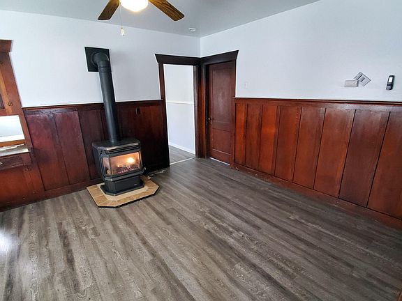 Dining Room with pass-through to kitchen on left side of photo. Entrance to back bedroom through closed door on right.