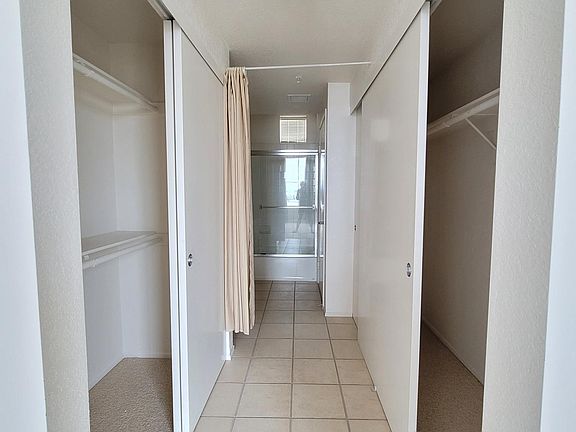 His and hers closets line the hallway into the master bathroom