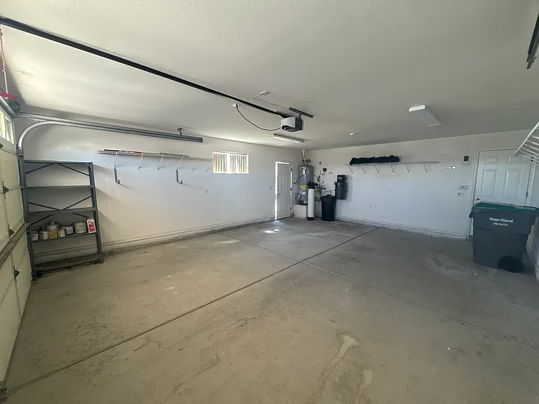 Spacious 2 car garage with shelving, water softener