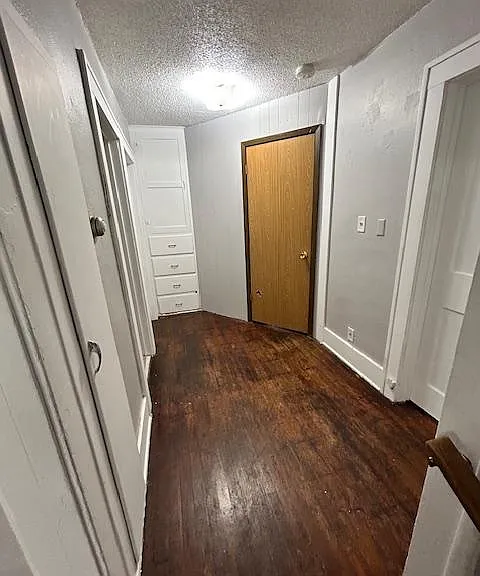 Central hallway (standing at the kitchen doorway). On the left is the bathroom and bedroom #1. Some built in storage. The brown door is the main living space or a potential bedroom. To the right is bedroom #2.
