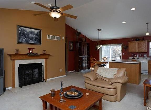 Vaulted living room with wood burning fireplace.