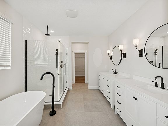 Primary bath features dual freestanding vanities