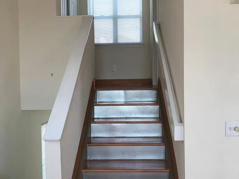 Stairs to upper floor with private primary suite
