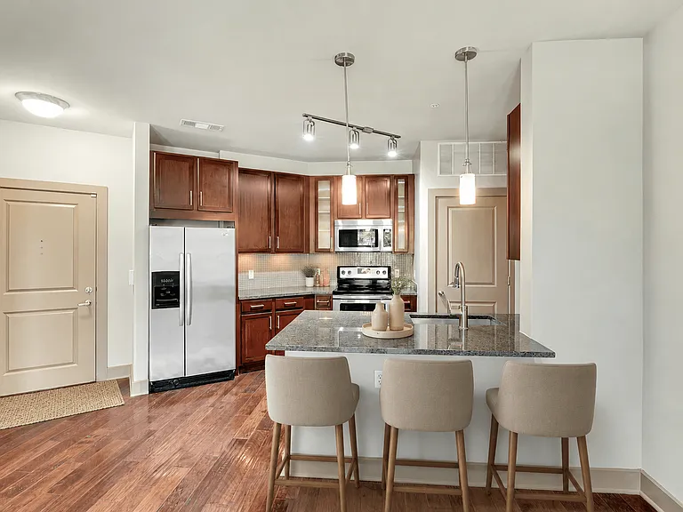 A kitchen with a table and chairs in front of it.