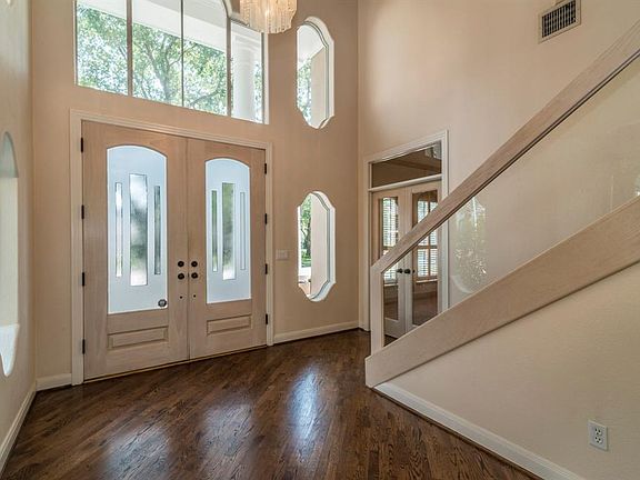 Foyer has distinctive windows, glass French doors to study.