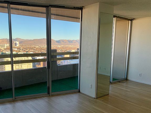 Living area with floor to ceiling windows and lg patio