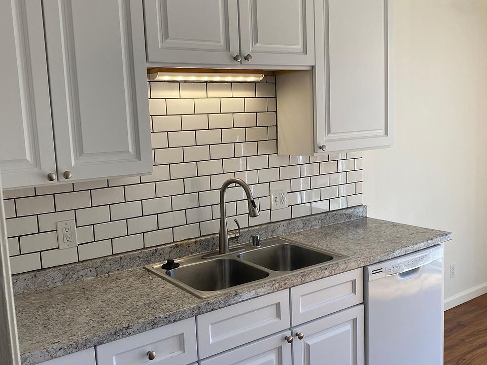 Remodeled kitchen with dishwasher, electric range & tile backsplash