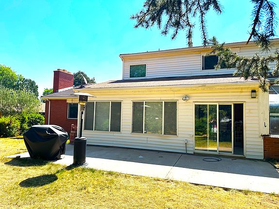 Back of house showing patio, sliding door to sunroom, and BBQ grill and heater. Patio furniture is also included with the house.