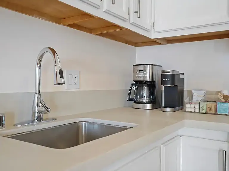 Coffee station ready to kickstart your mornings, complete with an espresso machine and drip coffee maker.