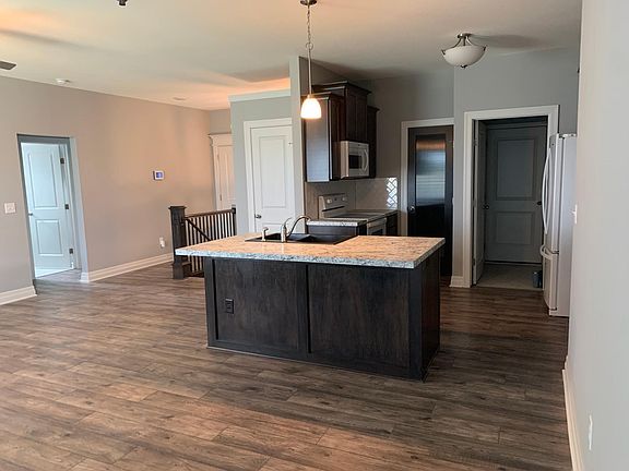 Kitchen island, pantry, laundry room, closet, dinette, living room, and door to the back patio.