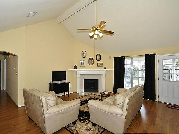 Wall of windows along the rear provide view of covered patio and backyard from this spacious den (16x16) with high ceilings.