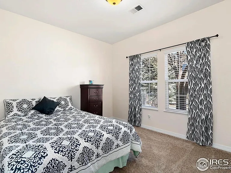 2nd bedroom overlooks outdoor grassy greenbelt