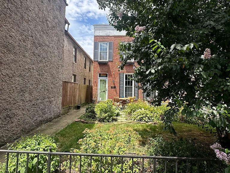 Street view of historic house, lush lawn and garden on Federal Hill, 2024