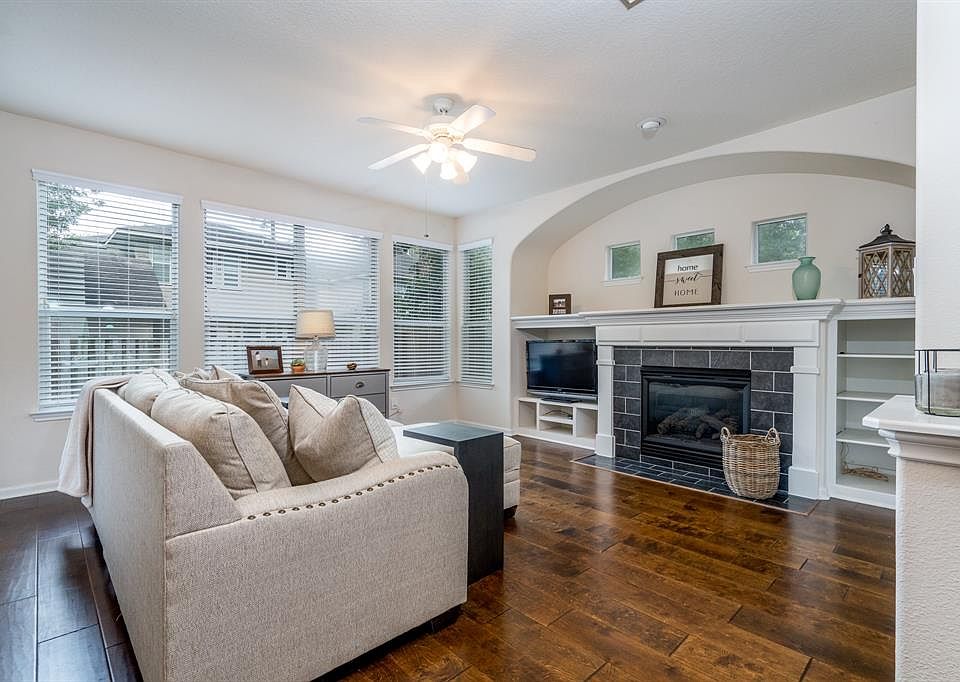 Charming home in Alden Bridge a community in The Woodlands. Cozy den is anchored by a fireplace.