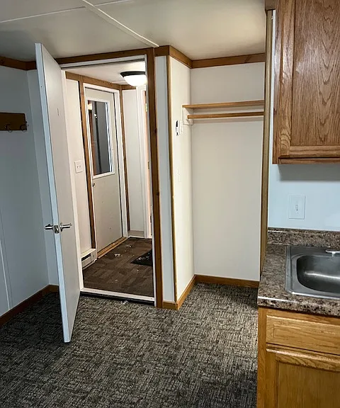 Private entry door to corridor with shared laundry.