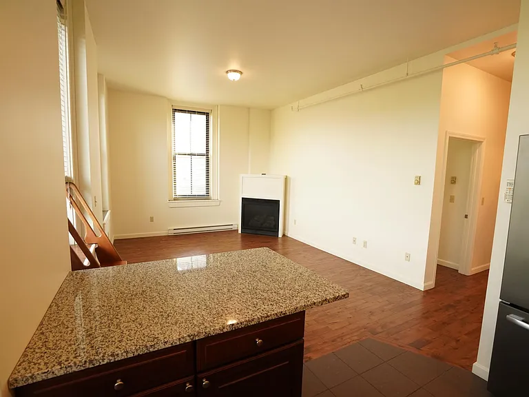 View of living room with fireplace from kitchen.