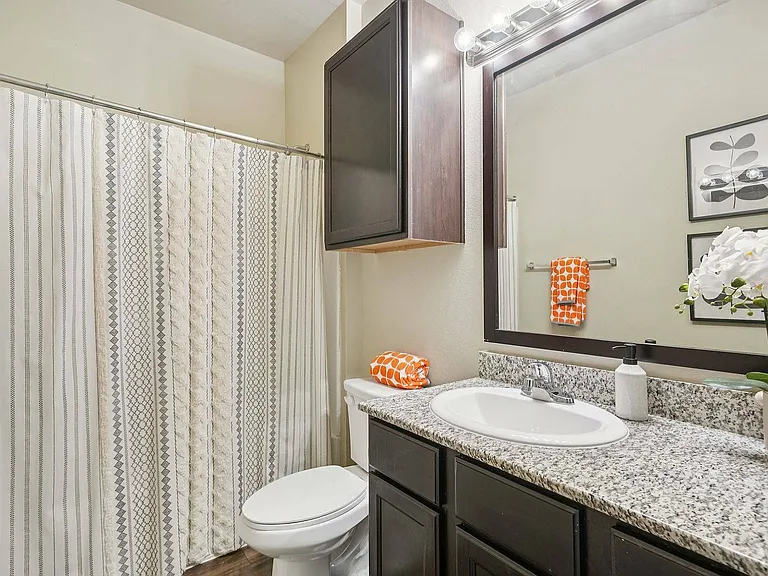 Experience luxury in every detail with granite countertops and stylish wood-style flooring in your bathroom at Arroyo Seco Villas.