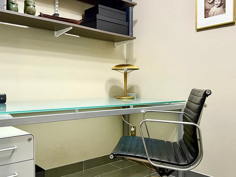 Enclosed office off main hallway includes sizable glass top desk, Eames chair, HP printer and original MCM desk lamp