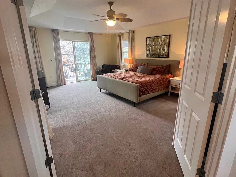 Main suite showing sliding door to balcony/porch with outdoor chairs