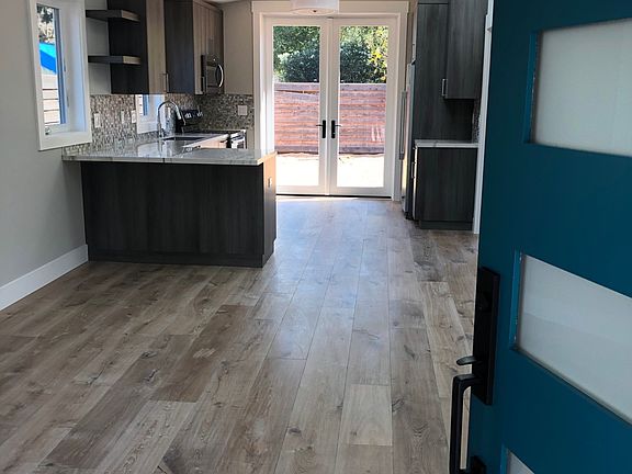 View from the front door through living room, kitchen and to the backyard. Backyard has been landscaped since this photo was taken.