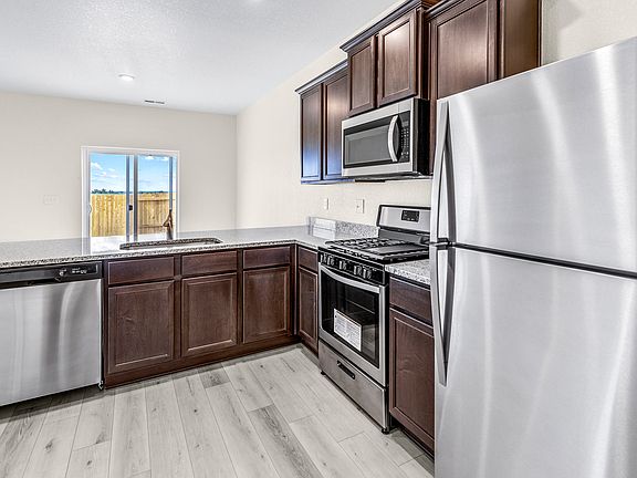 Upgraded kitchen with espresso cabinets, granite countertops, and an undermount sink.
