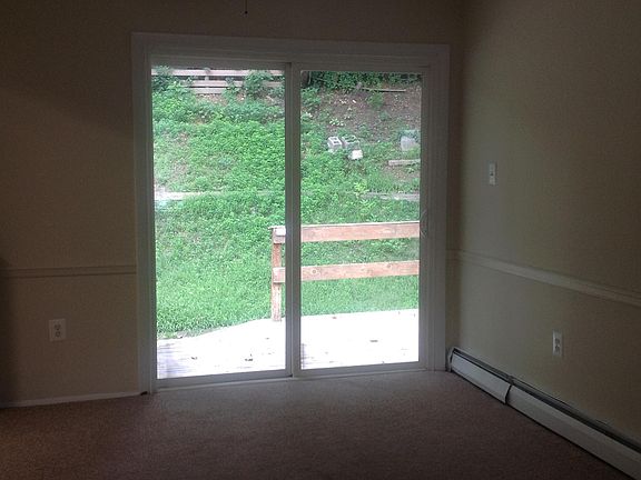 Dining room with sliding glass door to deck, patio the length of house and fenced yard.