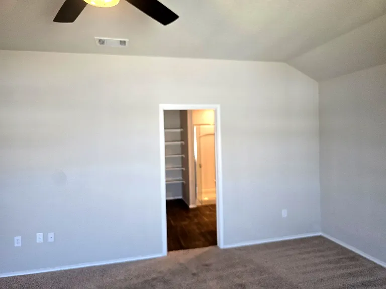 Spacious primary bedroom with clean and modern primary bathroom with ample space and storage.