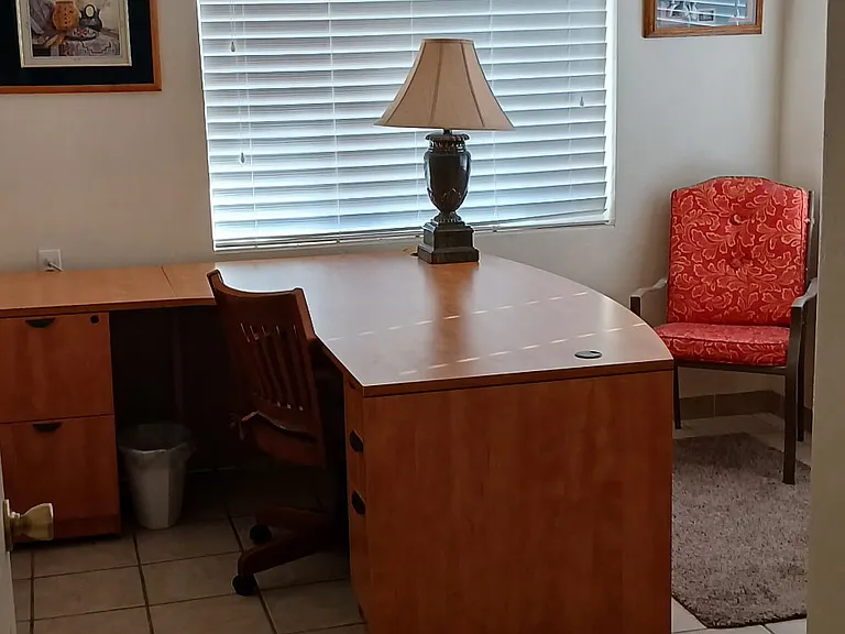 The office features a large desk and shelf space.