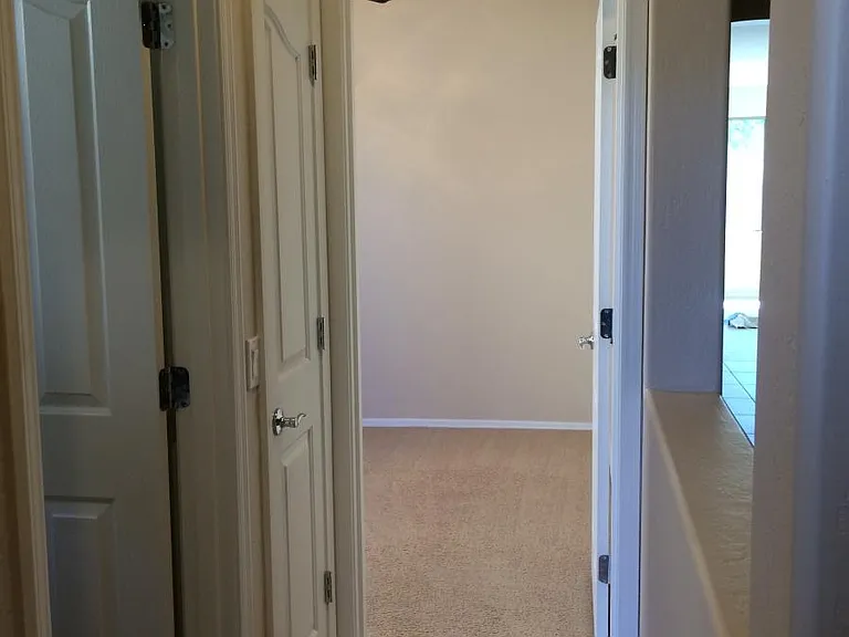 Divided hall with middle bedroom in front and a linen closet and bathroom to the left.
