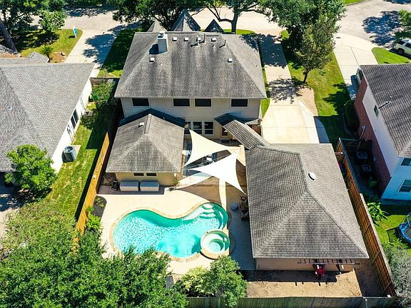 Another breathtaking aerial view focuses on the back of the home where we have a closer look at your personal backyard oasis! The roof was replaced in 2015.