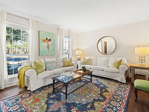 Living room with dark hardwood / wood-style flooring and crown molding