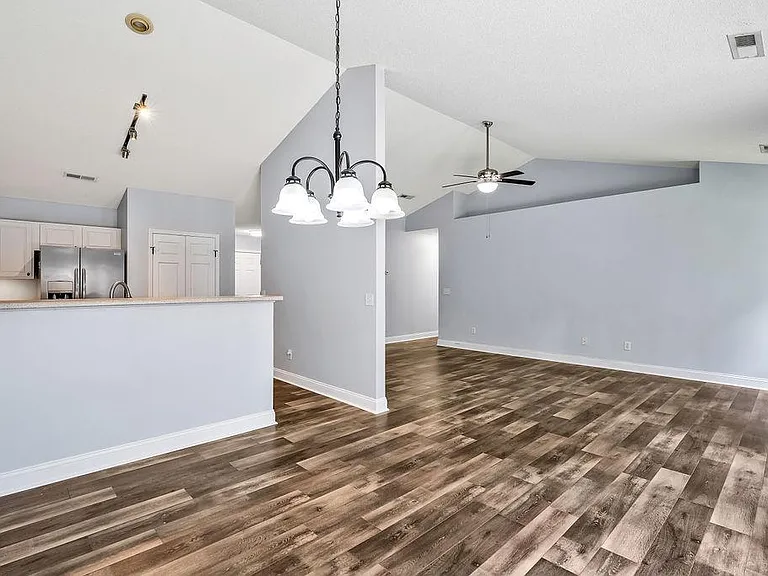 From the dining room, view of kitchen (left), hallway (center), and living room (center-right).