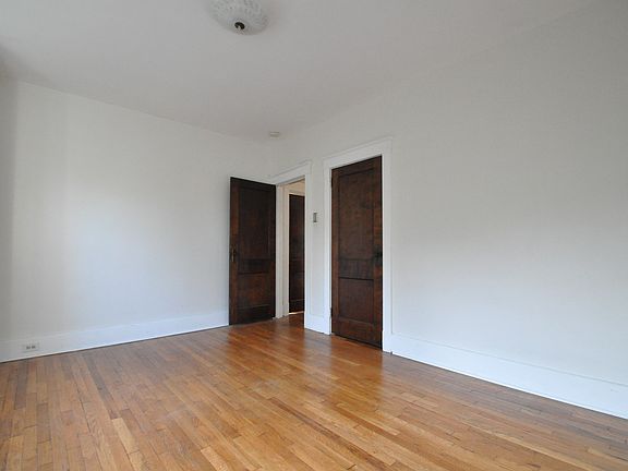 Bedroom 2 from the corner, looking through the open door to the hallway. The closet door is on the right.