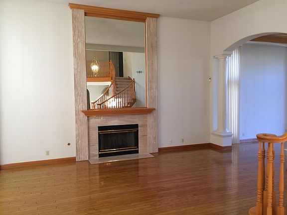 Formal Living Room with high cathedral ceiling, dramatic mirror, hardwood floor. (View 1)