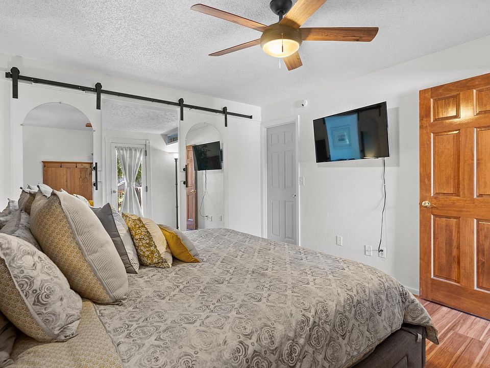King size bed and flat screen TV. White door leads to laundry and closet space.