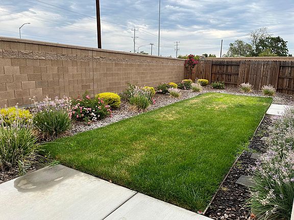 Landscaped backyard with areas for BBQ, seating, and planting
