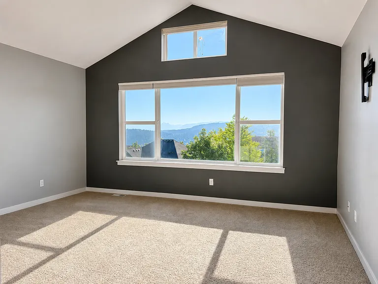 Primary bedroom with vaulted ceilings and an incredible mountain view. Also has a TV wall-mount already in place.