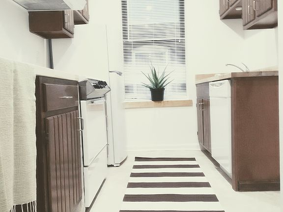 Mid-century modern kitchen features brand new butcher block countertops eating peninsula, new refrigerator freezer, new garbage disposal, dishwasher, vintage chrome oven, solid wood cabinets slotted for aeration, dark teak finish, stainless hardware.